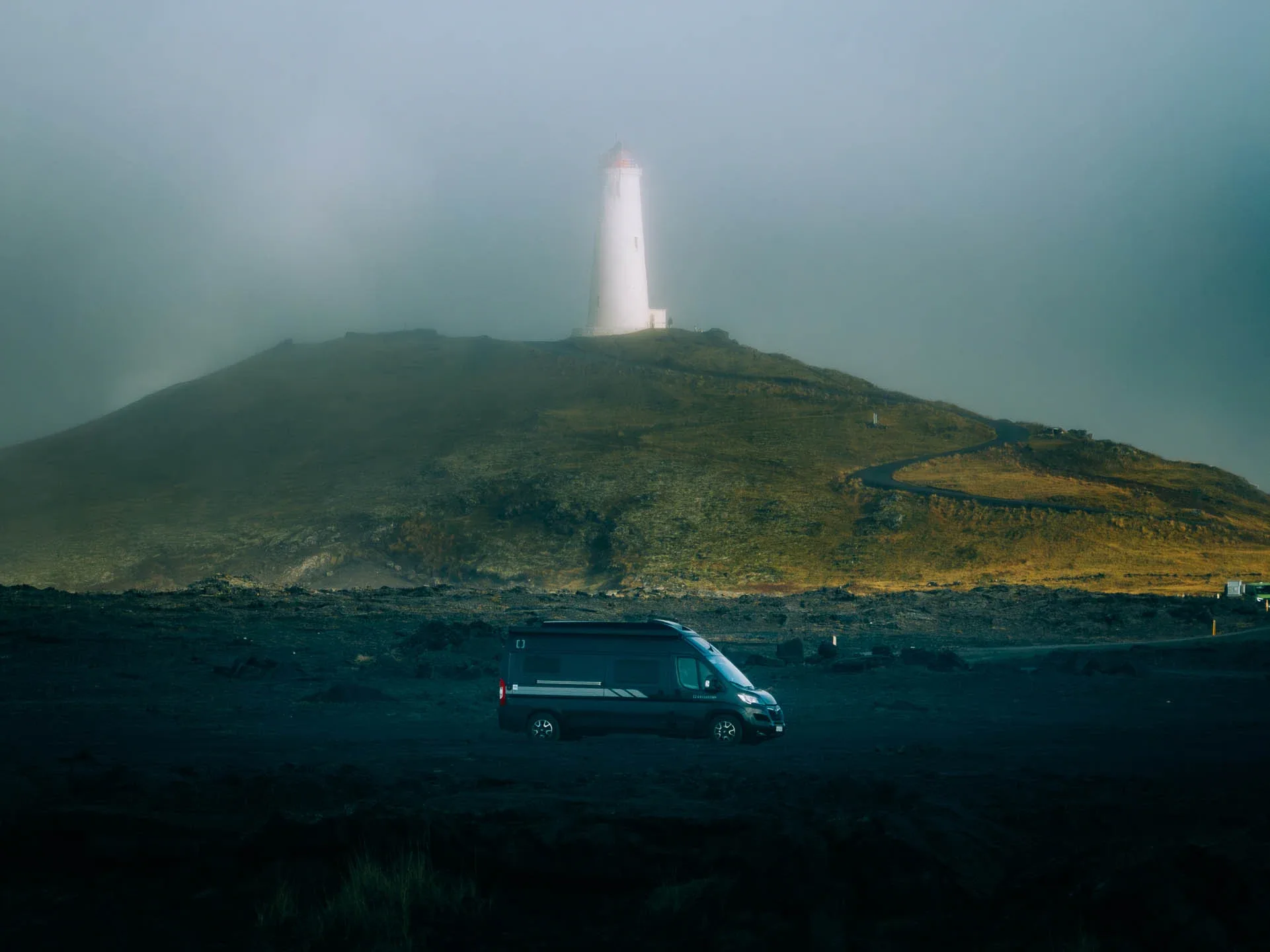 Campervan parked below a foggy lighthouse in Iceland, showcasing one of the iceland crowd free campervan routes on the Snæfellsnes Peninsula.