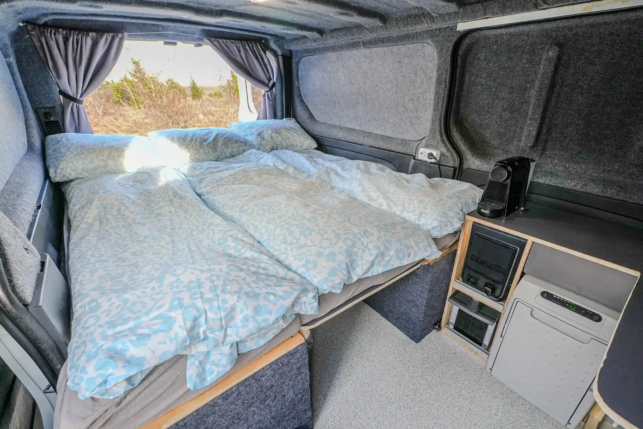Interior bed setup inside Foxie Campers Trafic 3 campervan with premium bedding for three travelers