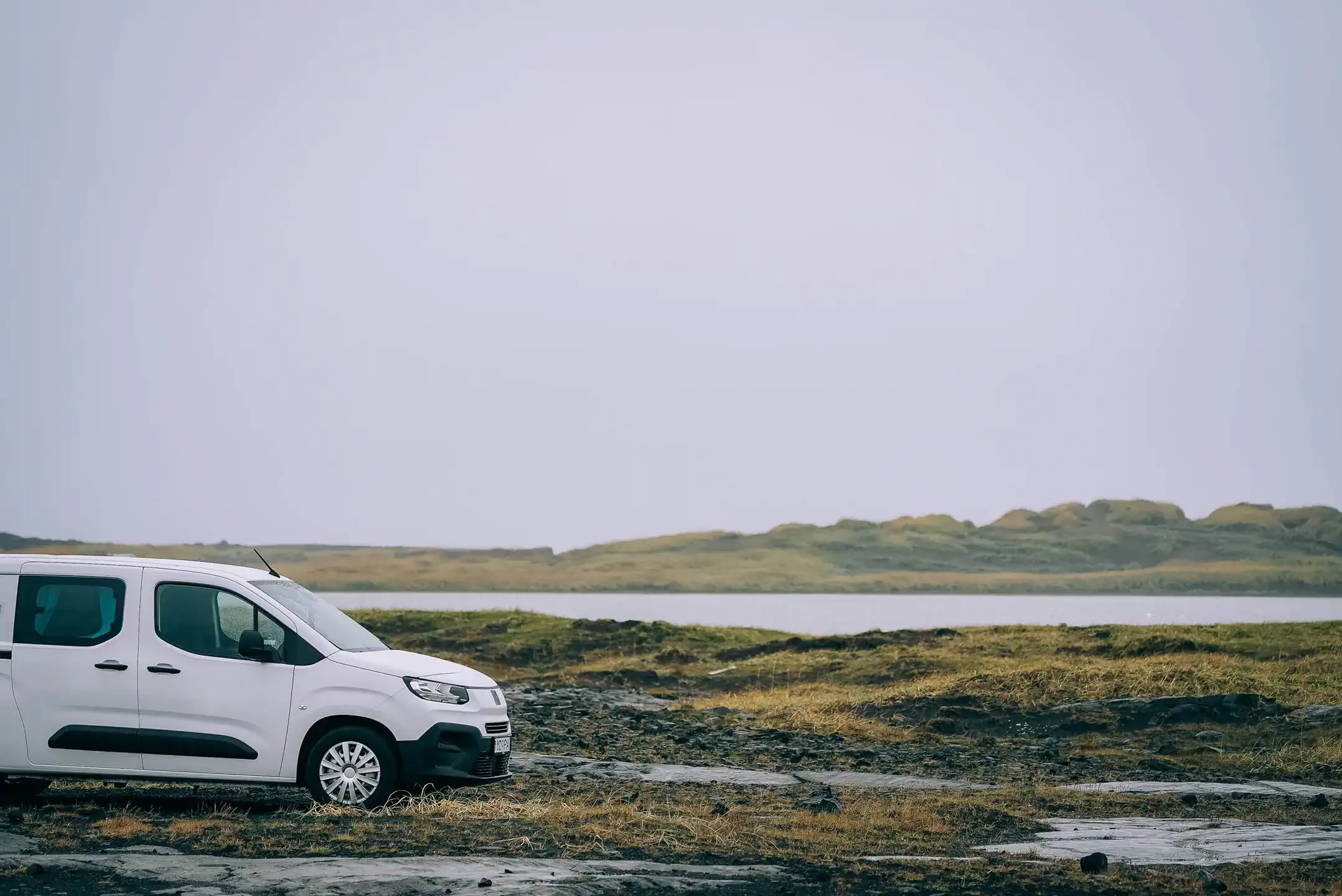 Fiat Doblo campervan rental Iceland parked beside a lake