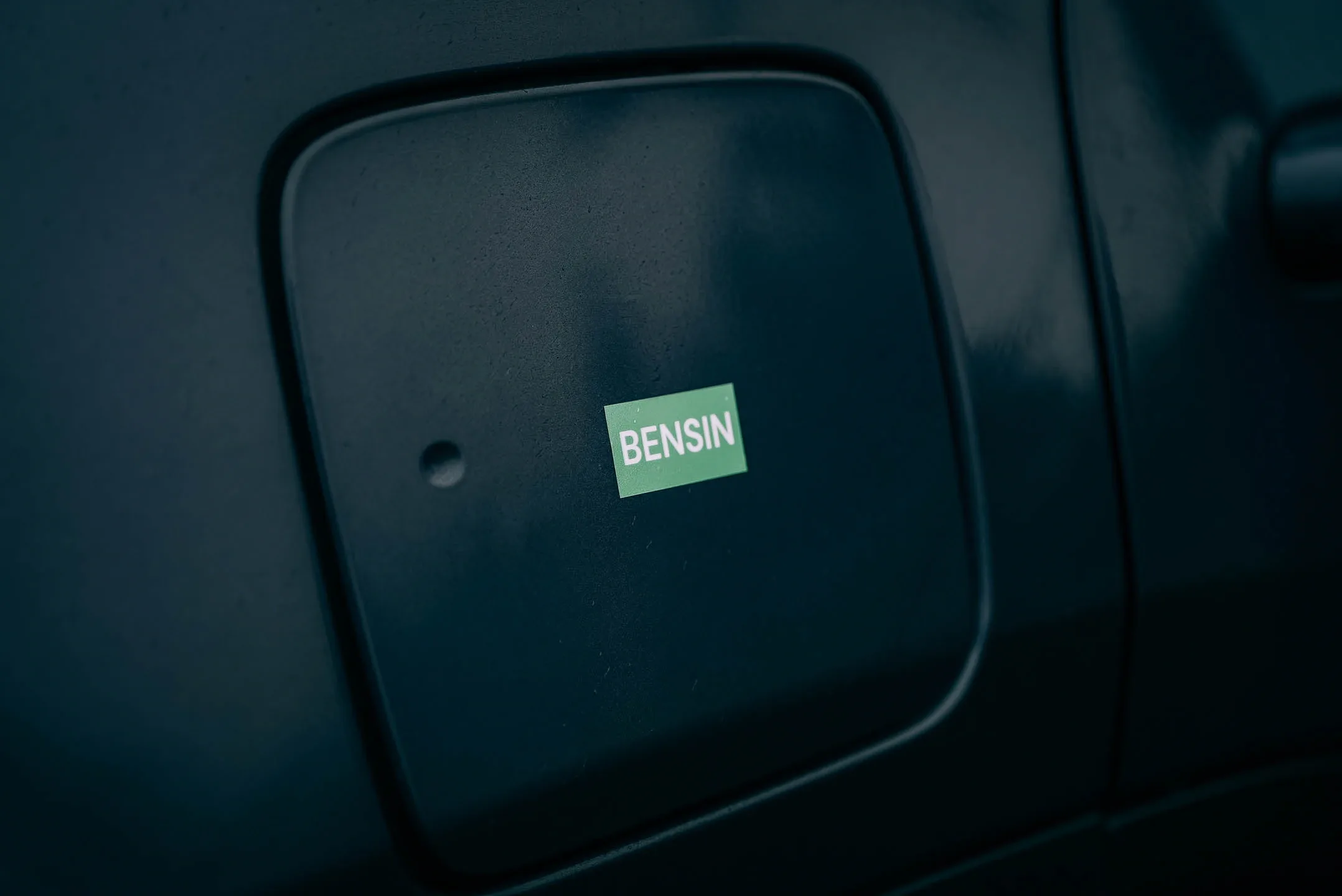 lose up of a “Bensin” petrol label on a vehicle fuel cap used at gas stations in Iceland, showing the correct fuel type for travelers 