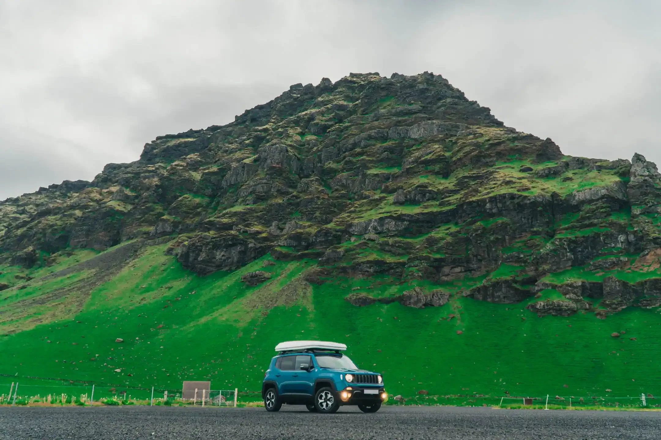 RV hire Iceland Jeep Renegade with roof tent parked in front of a green mossy mountain landscape