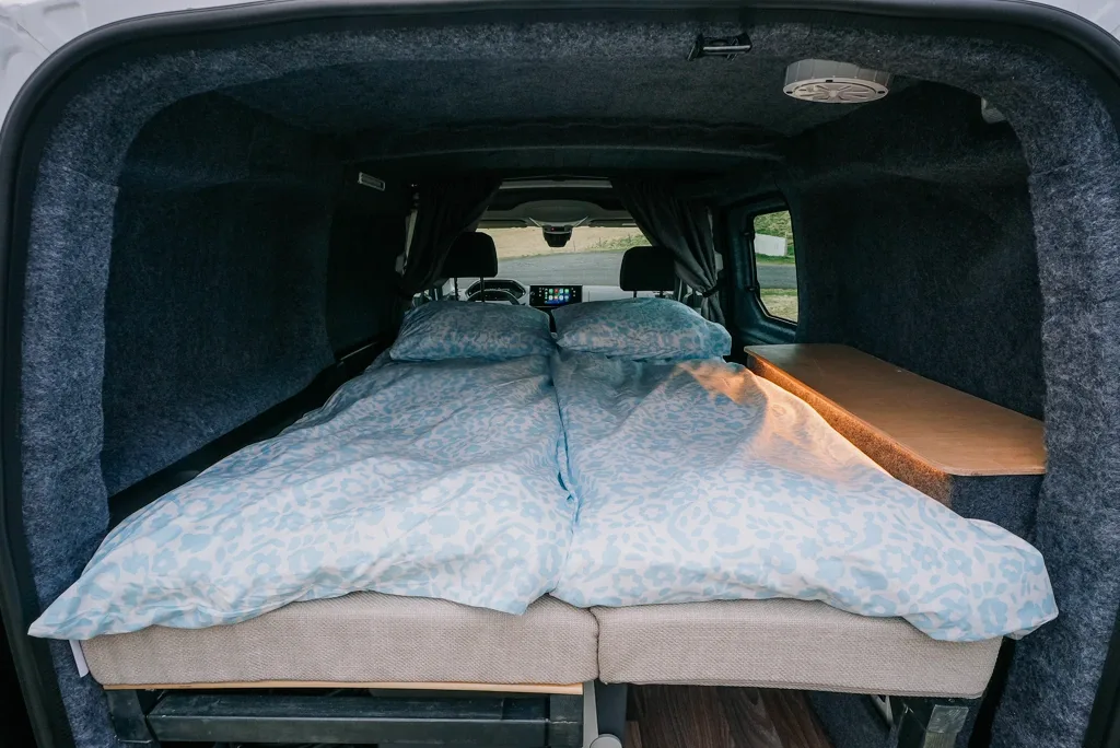 Premium 2 includes bedding, kitchen equipment, fridge, gas stove, water jug, table, chairs, heating, and off-grid power for two travelers.