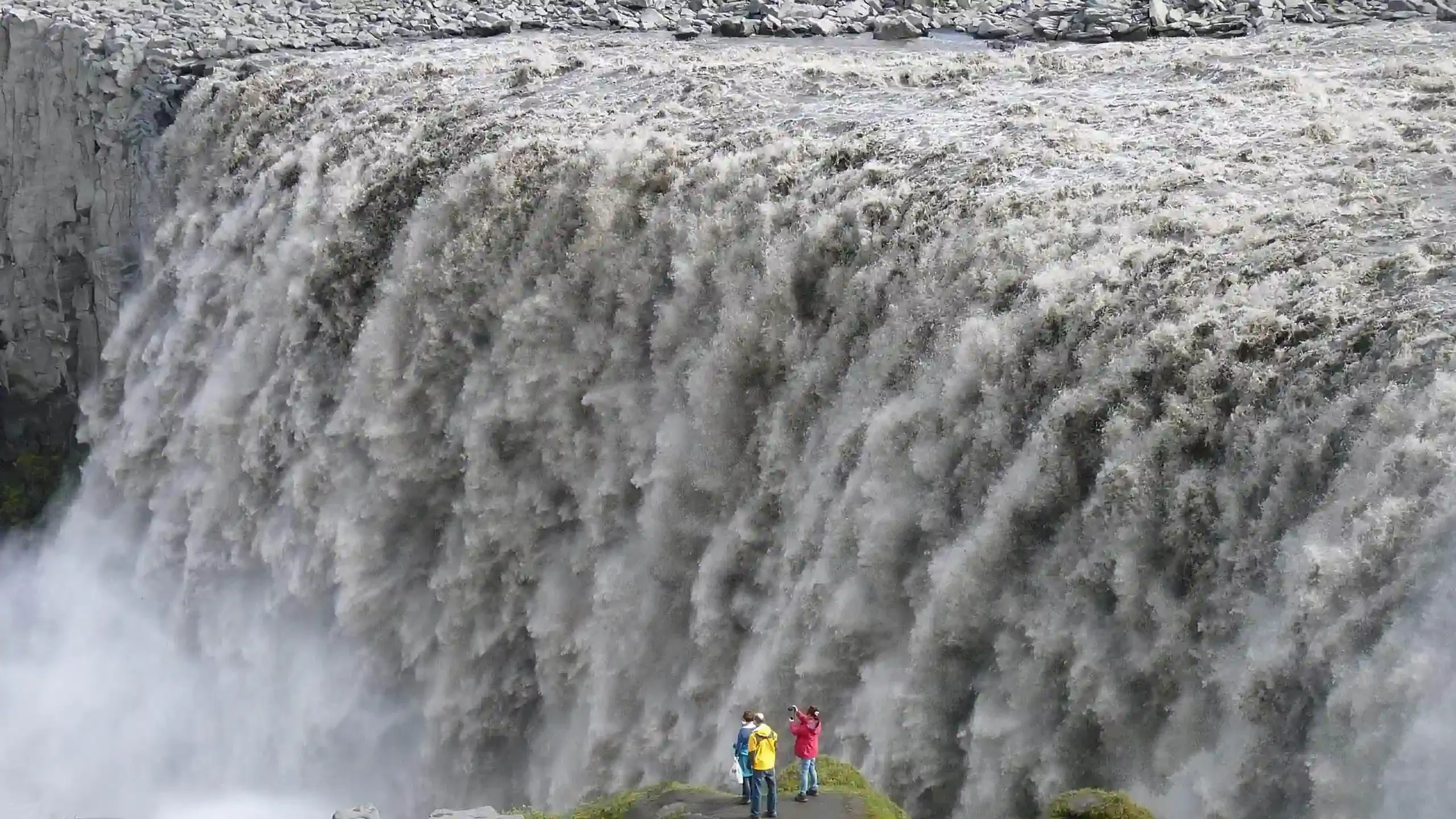 North Iceland travel guide photo of Dettifoss waterfall with visitors standing at the viewpoint near the powerful cascade