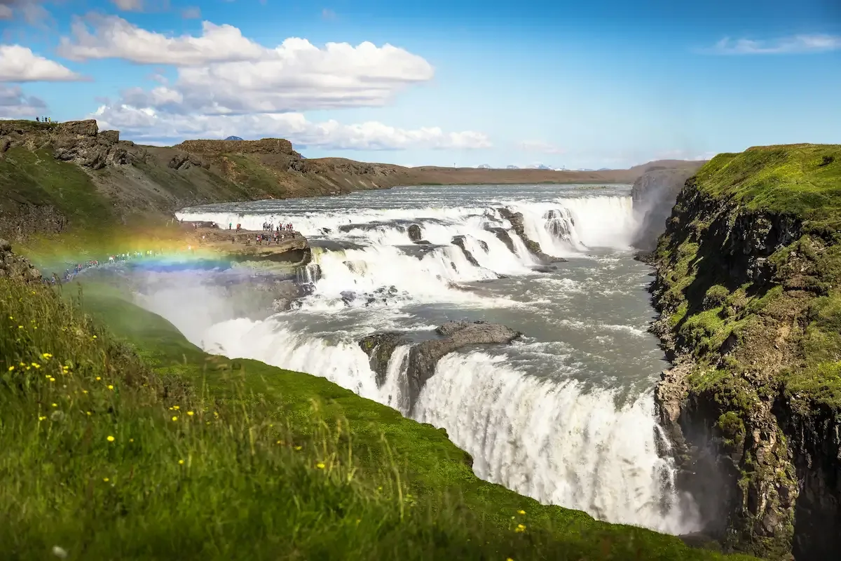 Gullfoss waterfall cascading into a canyon with rainbow mist on Iceland’s Golden Circle route