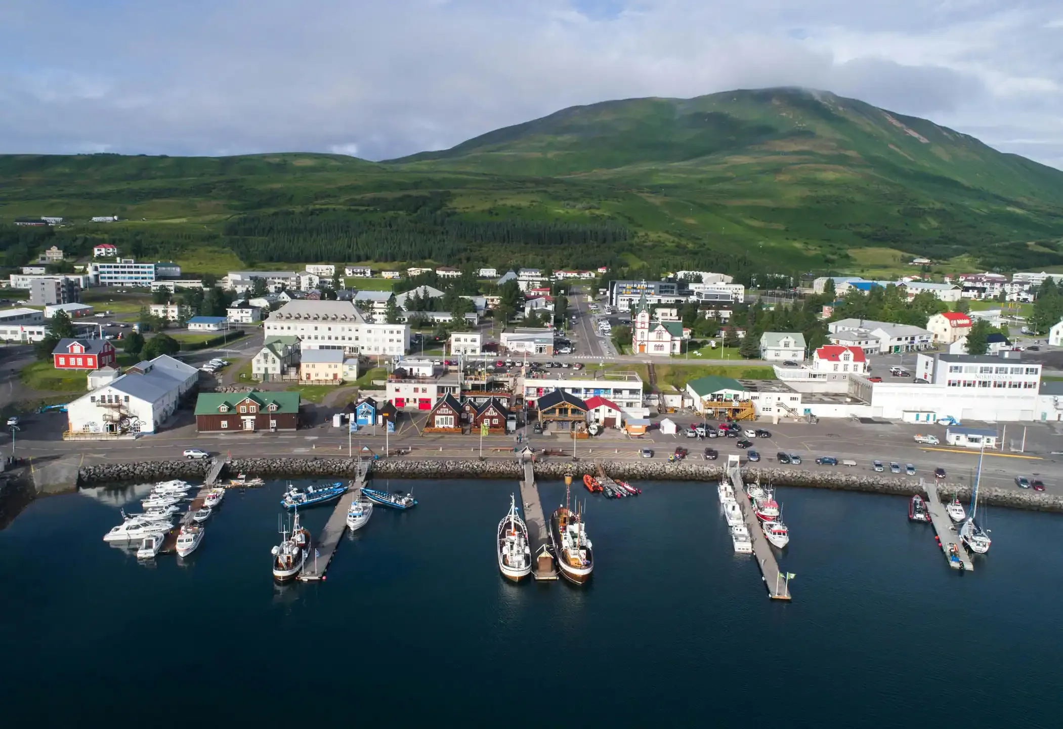 North Iceland road trip stop in Húsavík harbor with fishing boats and colorful houses
