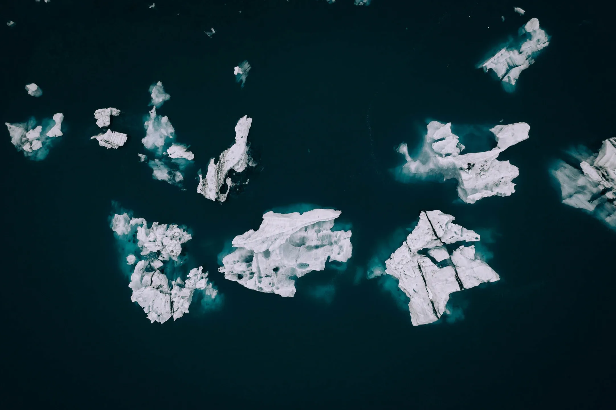 Icebergs drifting in a glacier lagoon within Vatnajökull National Park, aerial view 