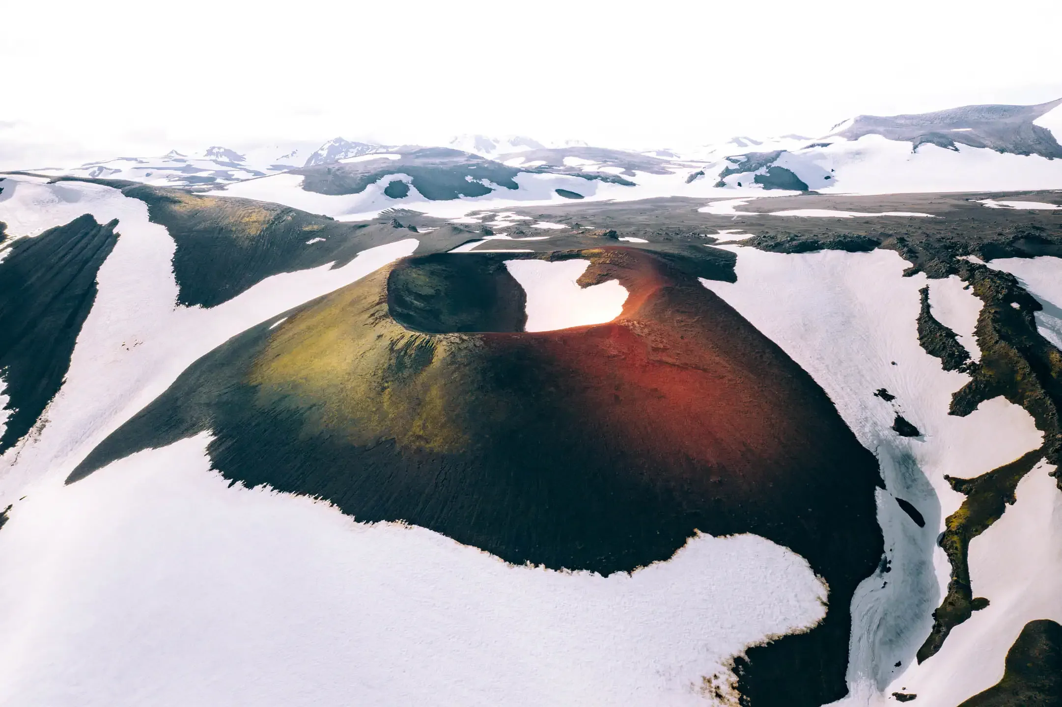 volcanic crater in the Icelandic Highlands surrounded by snow during summer highlands adventure
