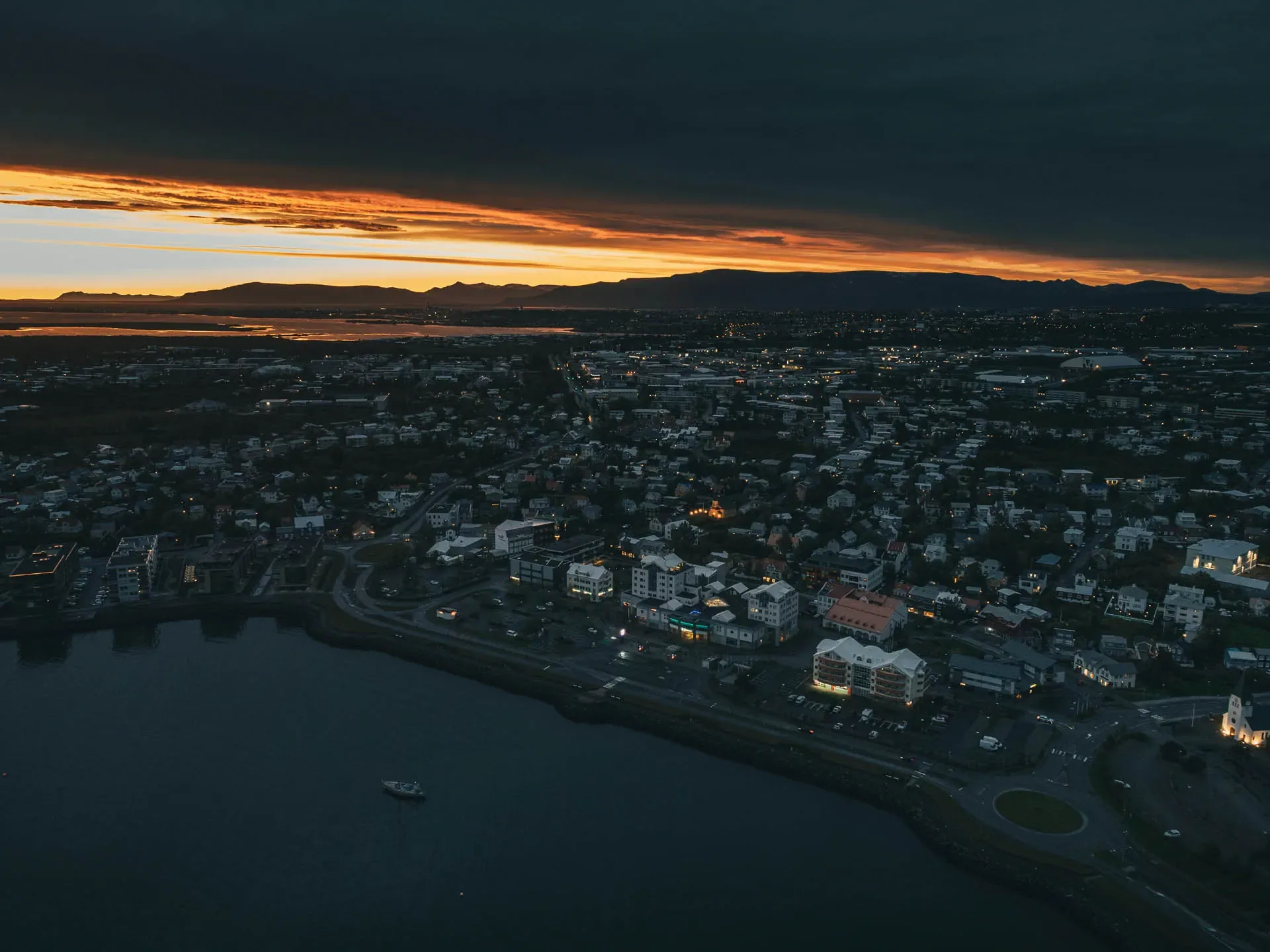 Aerial view of an Icelandic town at sunset, illustrating accommodation and daily living costs when traveling in Iceland in USD