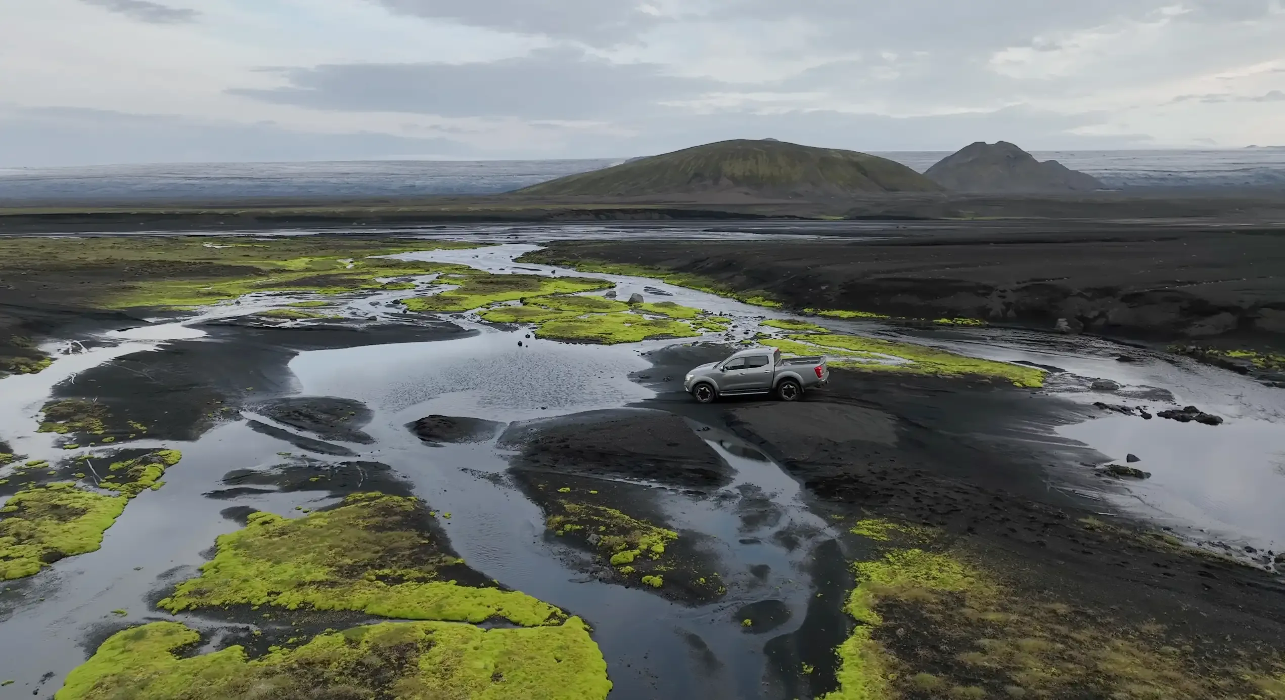 A 4x4 fording a marked river crossing on an Iceland F-road