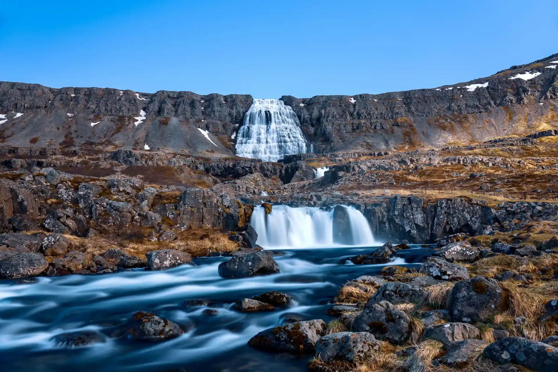 Dynjandi waterfall in the Westfjords of Iceland, a multi-tiered waterfall surrounded by rocky landscapes and a popular stop on a Westfjords campervan trip.